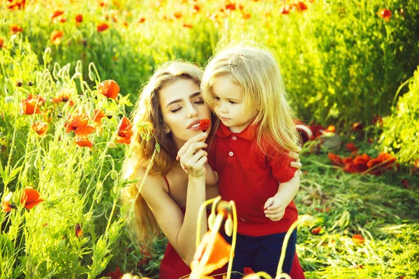 Kid, small boy at mother or sister in poppy field — Stock Photo, Image