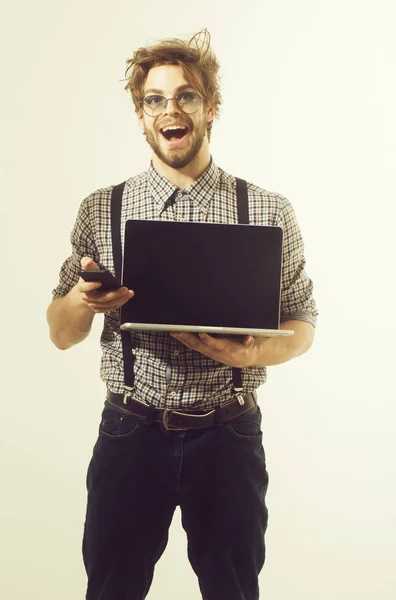 Lycklig stilig man talar på smartphone med laptop — Stockfoto