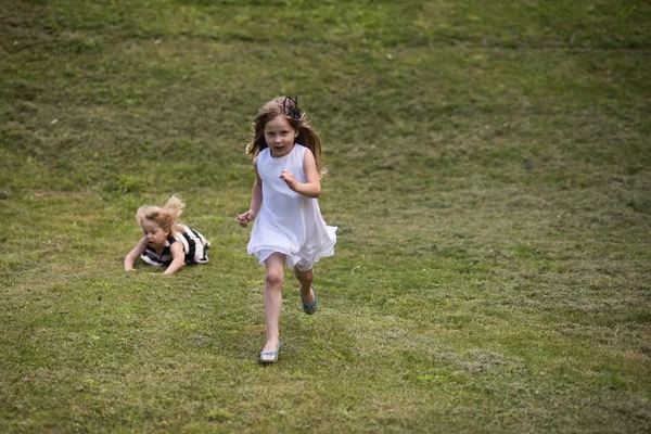 Dzieci uruchomić i spadnie na zielonej trawie na letni dzień — Zdjęcie stockowe