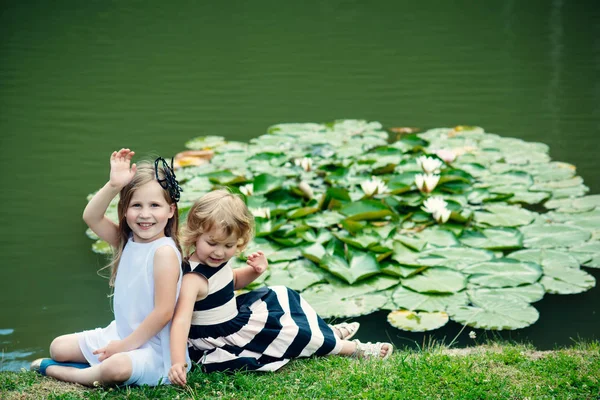 Діти щасливі посмішки на зеленому озерному пейзажі — стокове фото