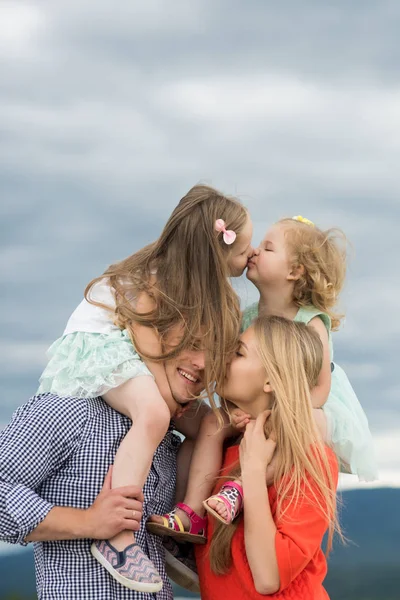 Dívky polibek na bedrech otec matku na zatažené obloze — Stock fotografie