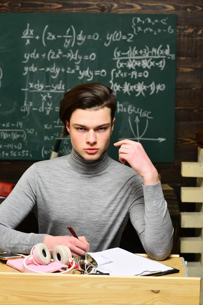 Students preparing for exams in classroom interior behind table. Student passing an exam euphoric girl watching a laptop in the class. Students campus education knowledge concept