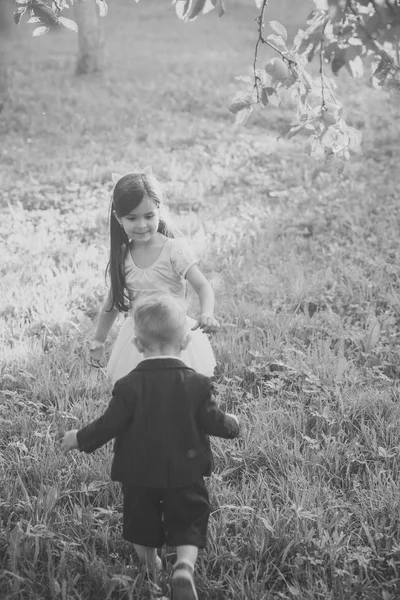 Little boy and girl play on green grass, energy — Stock Photo, Image