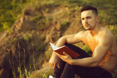 Kitap açık olan dalgın kaslı adam