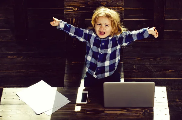 Niño feliz en la oficina con el ordenador portátil, teléfono, hoja de papel — Foto de Stock