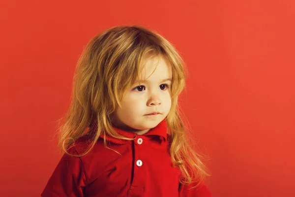 Pequeno menino com longo cabelo loiro na camisa vermelha — Fotografia de Stock