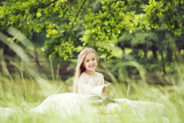 Kleines Mädchen im Kleid mit Obstkorb und Buch — Stockfoto