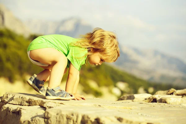 Chłopiec dziecko odgrywa na skałach — Zdjęcie stockowe