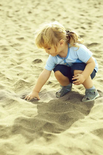 Söt baby boy spela med sand — Stockfoto