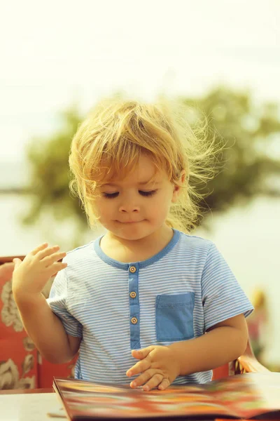 Söt baby pojke läser menyn kort — Stockfoto