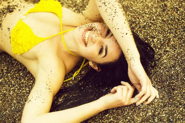 Bastante feliz chica se encuentra en traje de baño amarillo superior en la playa —  Fotos de Stock