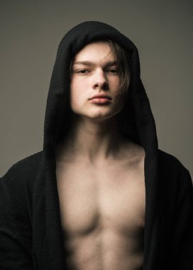 Siyah hood, gri arka planda emin yüz adam. Erkeklik kavramı. Maço siyah bornoz ile kukuleta, yakın çekim. Pürüzsüz cilt üzerinde yüz, boyun ve göğüs kameraya bakarak adam.
