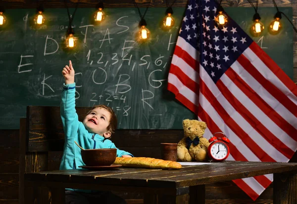 Retrato de niño caucásico con la mano levantada con bandera americana en el fondo —  Fotos de Stock