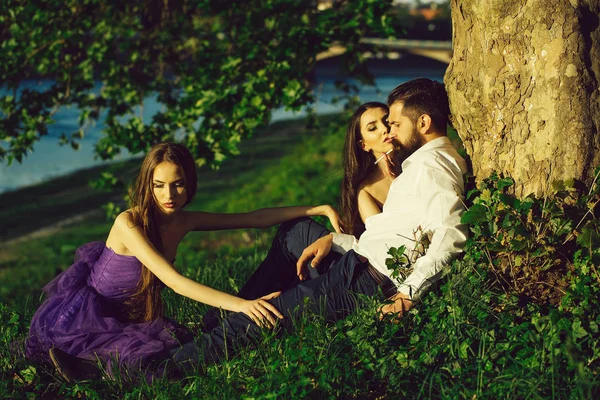Бородатий чоловік і дві жінки на траві — стокове фото