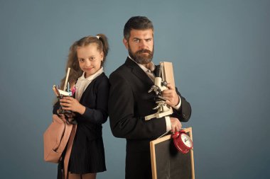 Öğretmen ve kendinden emin yüzlere mavi arka plan ile kız öğrenci