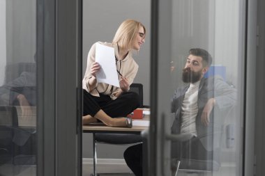 İş kadını ve işadamı kurumsal rapor yazmak. İş kadını ve sakallı adam birlikte ofiste çalışmak, yoğun bir gün ofiste