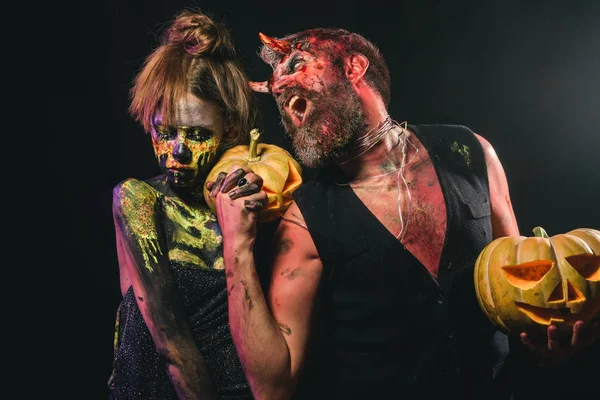 Esqueleto de la mujer de Halloween y el hombre con cuernos sostienen calabazas — Foto de Stock