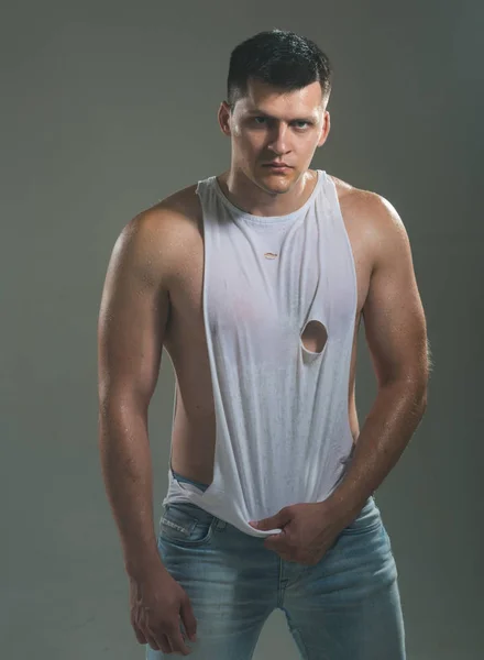 El hombre a la moda en la camiseta de moda y los vaqueros de moda. Modelo de moda con cabello elegante —  Fotos de Stock