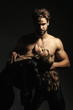 Gövdesi kaslı bir adam kadını uzun saçlarıyla tutuyor.