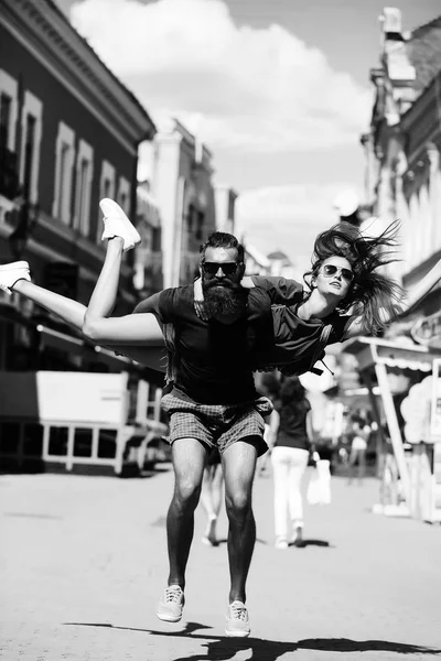 Smiling handsome man jumping with cute girl on back