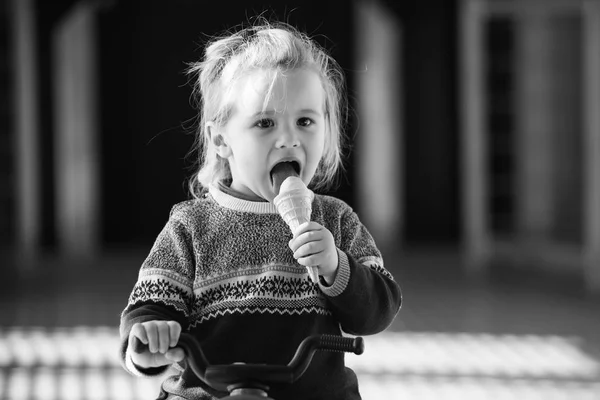 Bambino in maglione che mangia, leccare il gelato — Foto Stock