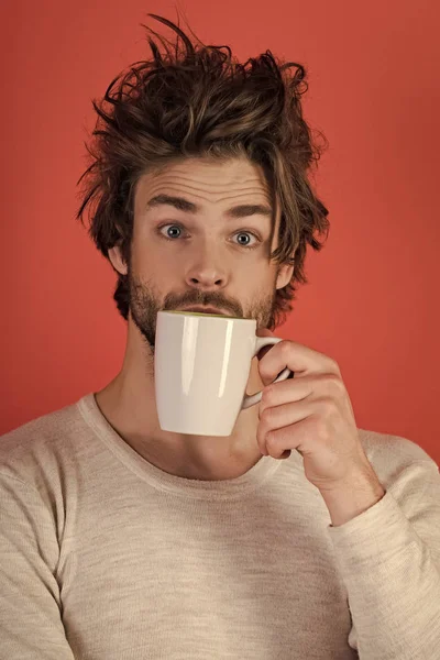 Chico sorprendido con taza de té sobre fondo rojo . — Foto de Stock