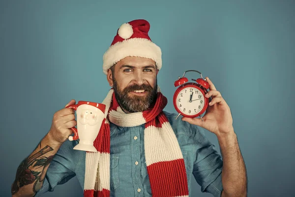 Kerst man houd wekker en cup — Stockfoto