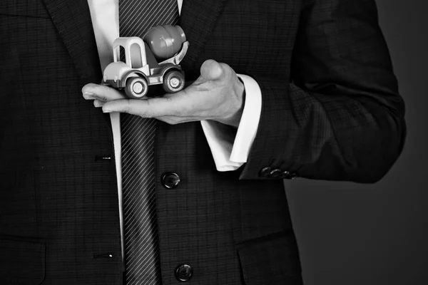 Coche de juguete en la mano del hombre, hombre de negocios en traje azul — Foto de Stock