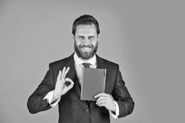 Hombre, feliz hombre de negocios tiene un cuaderno, libro rojo en la mano — Foto de Stock