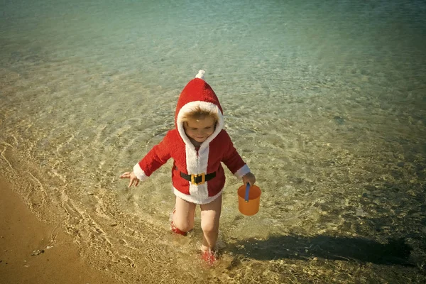 Szczęśliwe dziecko Boże Narodzenie z wiaderkiem w wodzie. — Zdjęcie stockowe
