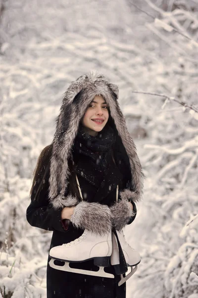 Girl smile with figure skates at trees in snow — Stock Photo, Image