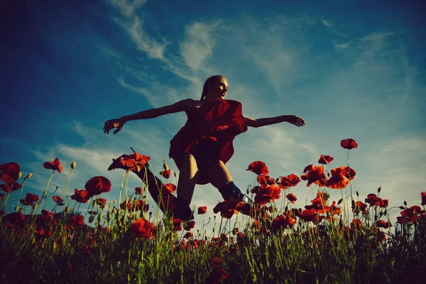 beauty model or jumping girl in flower field of poppy