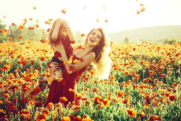 Rojo y verde, sonriente madre e hijo en el campo de amapola — Foto de Stock