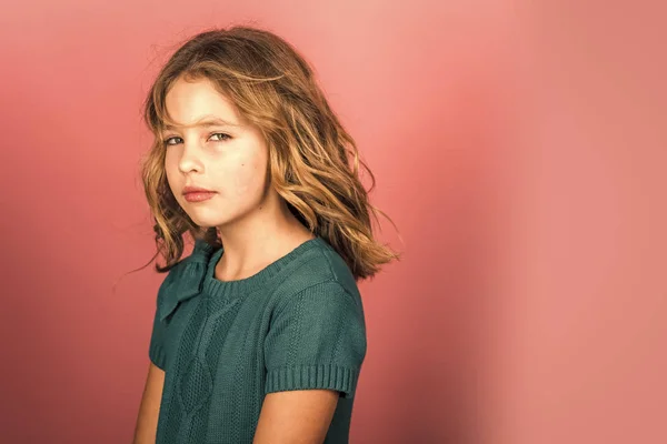 Charmante niedliche kleine Mädchen mit lockigen Haaren auf rosa Hintergrund. — Stockfoto