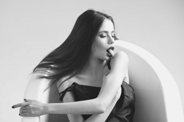 Uzun saçlı bir kadın, banyoda siyah ruj.