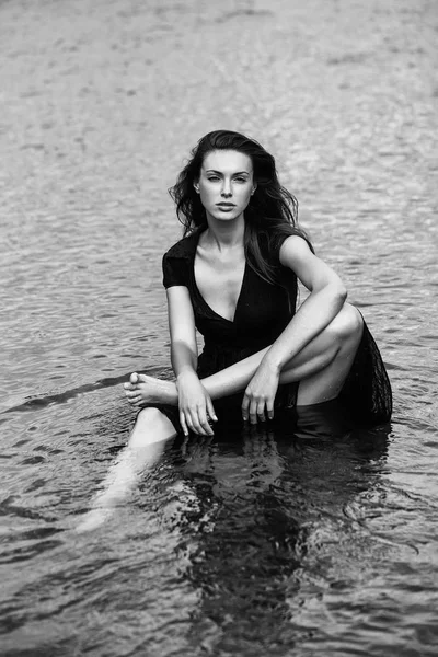 水に座っている若いセクシーな女性 — ストック写真