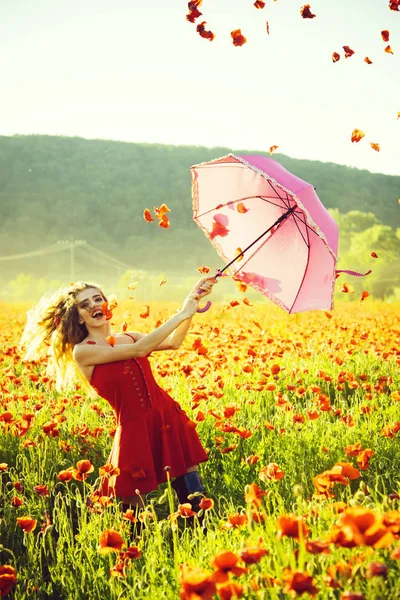 Regenschirm rosa Farbe bei Mädchen im Feld des roten Mohns — Stockfoto