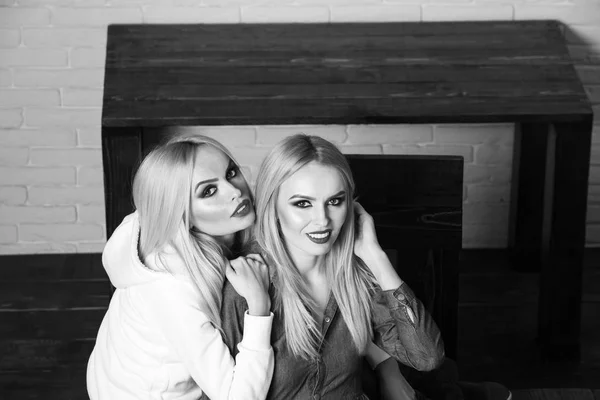 Portret van twee beste vrienden meisjes omhelzing in de buurt van houten tafel — Stockfoto