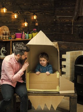 Ebeveynlik kavramı. Baba, baba, küçük kozmonot ile çocuk oyun karton kutudan yapılan roket oturup. Çocuk mutlu oturmak karton el roket yapımı. Çocuk çocuk oyun kozmonot, astronot.