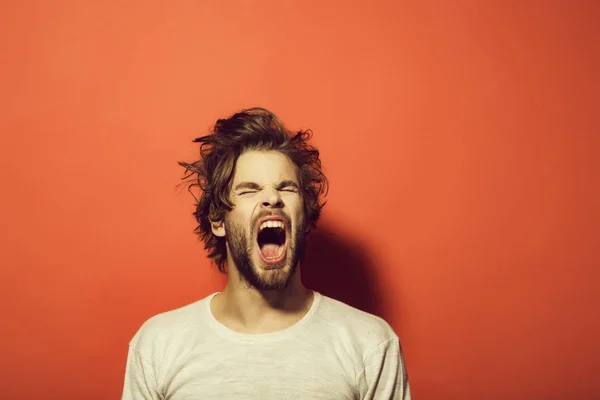Gridare o sbadigliare uomo con lunghi capelli spettinati, mattina, mal di testa — Foto Stock