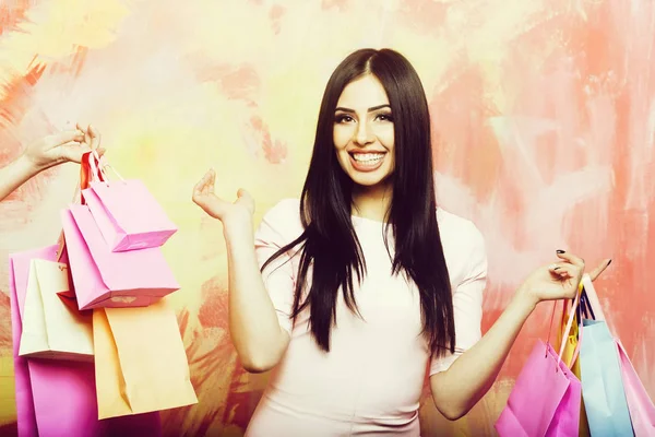 Mulher sorridente muito sexy com sacos de compras em fundo colorido — Fotografia de Stock