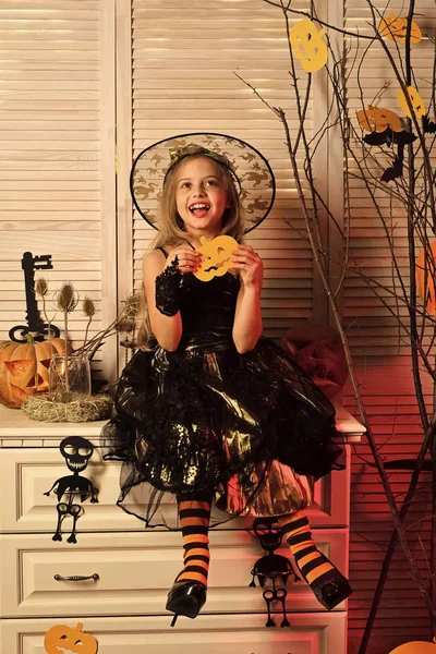 Kid in witch hat and costume holds paper jack lantern — Stock Photo, Image