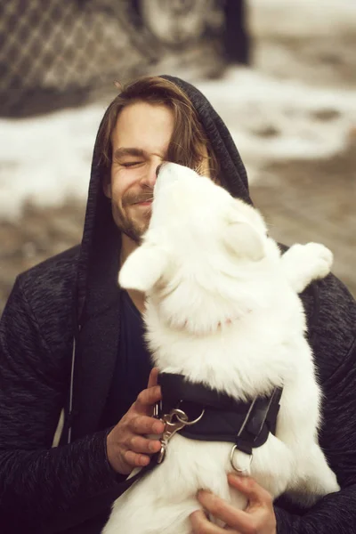 Roztomilý pejsek olizuje tvář šťastný psí muže — Stock fotografie