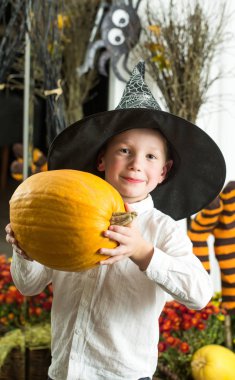 Cadılar Bayramı çocuk cadı şapka kabak portakal ile.