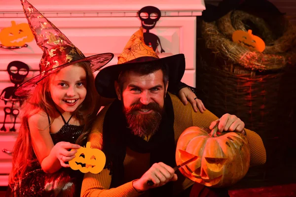 Wizard and little witch with Halloween decor.