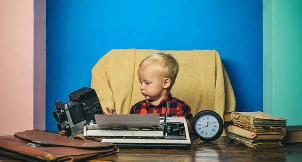 Press photographer work with vintage camera and typewriter. Little photographer typewrite at office desk