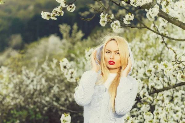 Mooie vrouw met blonde haren, rode lippen op florale achtergrond — Stockfoto