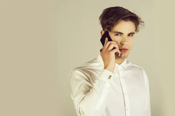 Hombre guapo en camisa blanca con gemelo hablando por teléfono — Foto de Stock