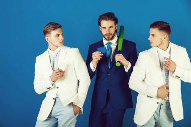 Beyzbol sopası mavi arka plan üzerinde tutan adam