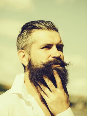 Mavi gökyüzü üzerinde sakallı adam